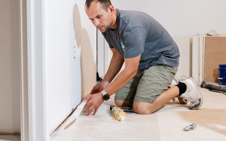 A professional installer from Daniel's Home Improvement carefully laying flooring material to ensure a smooth and even finish.