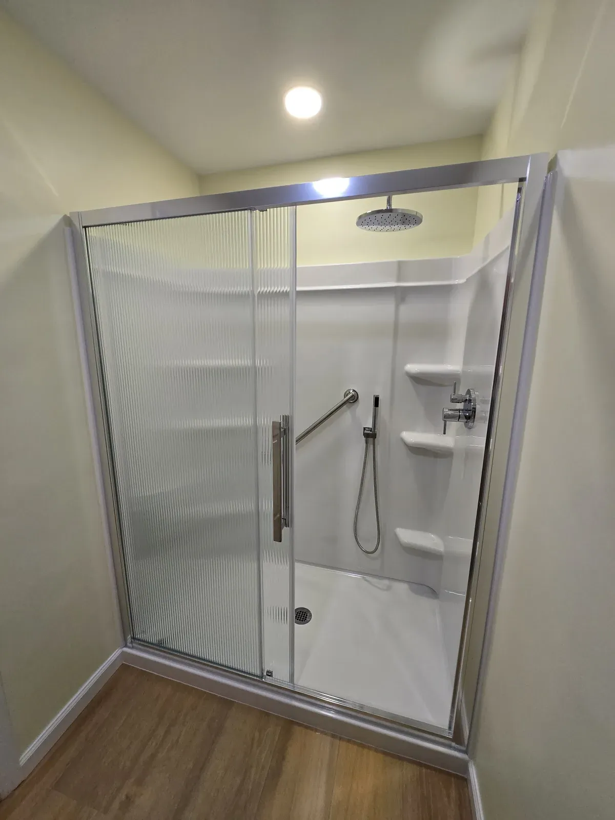 Four-piece acrylic shower with subway-tile pattern